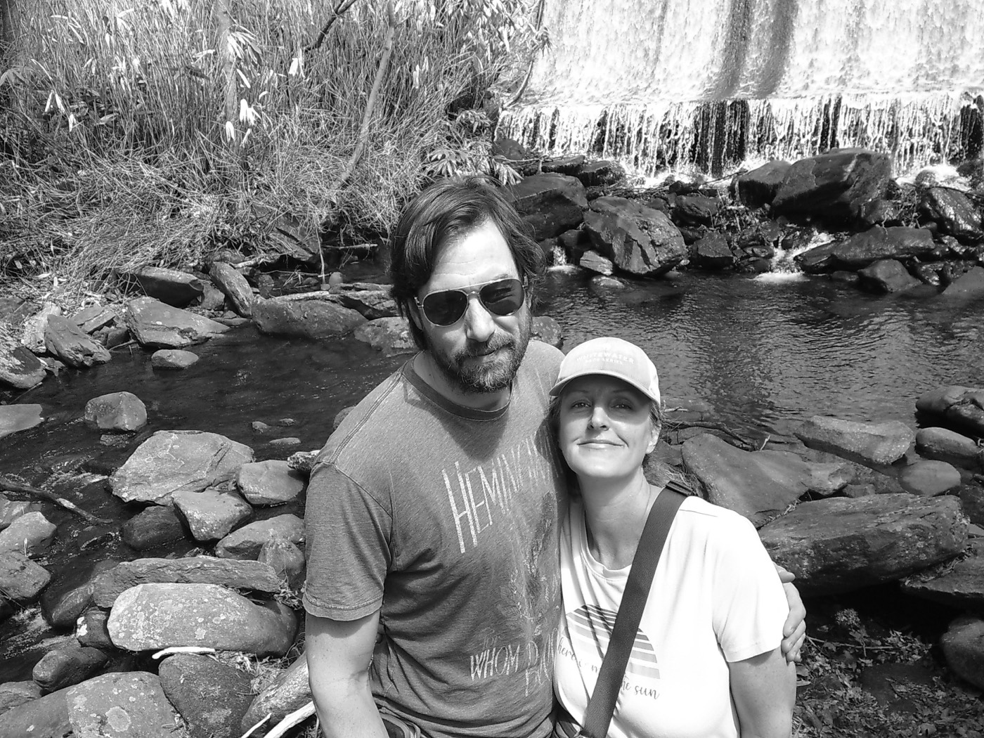 Two people standing beside a river
